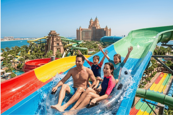 Happy family enjoying colorful water slides at Aquaventure Waterpark Atlantis Dubai
